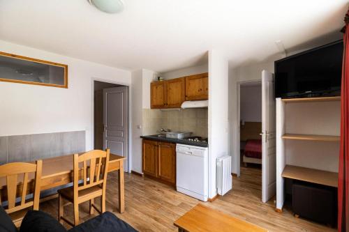 une cuisine et une salle à manger avec une table et une salle à manger dans l'établissement Les Chalets De Bois MÉan - D - Appartement sur les hauteurs des Orres 1800 MAE-3211, aux Orres