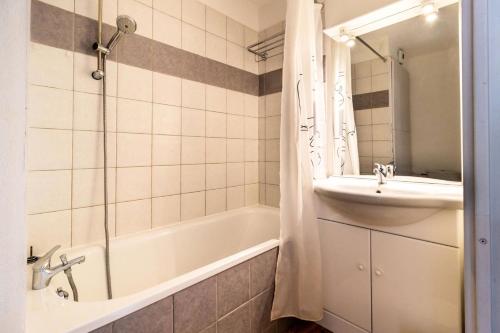 une salle de bain avec une baignoire et un lavabo et une baignoire tubermottermott dans l'établissement Les Chalets De Bois MÉan - D - Appartement sur les hauteurs des Orres 1800 MAE-3211, aux Orres