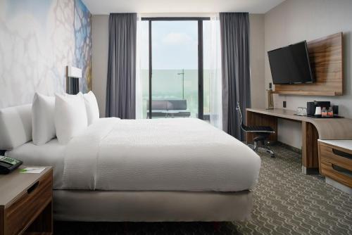 a hotel room with a bed and a desk and a television at Courtyard by Marriott Mexico City Toreo in Mexico City