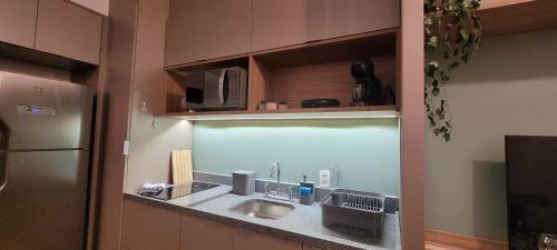a kitchen counter with a sink and a microwave at MOEMA54 - Studio novo e completo na melhor localização de Moema, ao lado do Shopping Ibirapuera in Sao Paulo