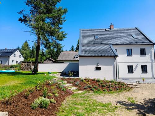 a white house with a garden in front of it at Chalupa Velká Javorská in Žandov