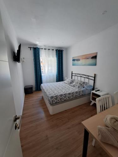 a bedroom with a bed and a table in a room at Aeropuerto Barcelona -Mi colibrí in El Prat de Llobregat