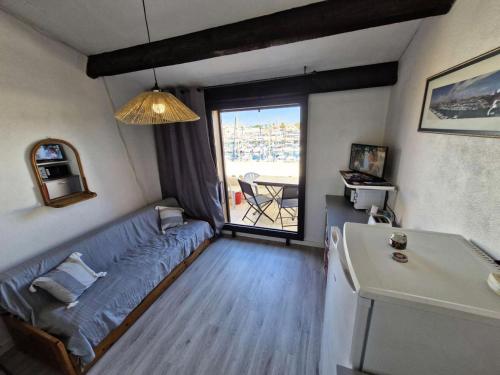 un salon avec un canapé et une grande fenêtre dans l'établissement Résidence Le Castellet - 2 Pièces pour 4 Personnes 501, à Leucate