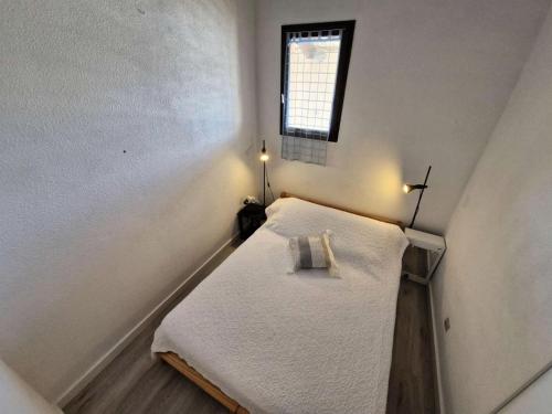 Cette petite chambre dispose d'un lit et d'une fenêtre. dans l'établissement Résidence Le Castellet - 2 Pièces pour 4 Personnes 501, à Leucate