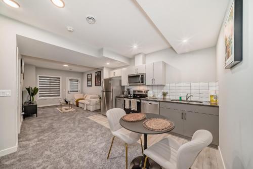 a kitchen and living room with a table and chairs at Cozy Basement Suite in Calgary