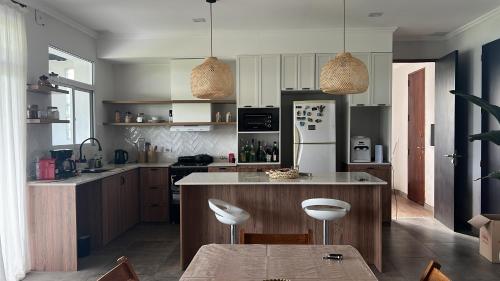 eine Küche mit weißen Schränken und eine Insel mit Stühlen in der Unterkunft Casa barrio privado in Laguna Brava