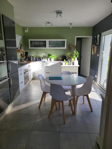 une cuisine avec une table et des chaises dans une cuisine dans l'établissement La Fontaine de Baron, à Baron-sur-Odon