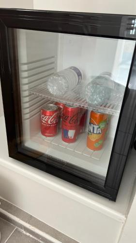 a refrigerator with three cans of soda in it at Jacuzzi sauna 5min pied gare in Les Mureaux