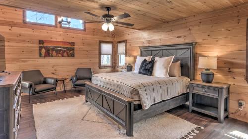 a bedroom with a bed and two chairs in a cabin at The Perfect Landing in Cherry Log