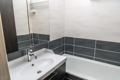 une salle de bain avec un lavabo et une baignoire dans l'établissement Résidence L'oustal - Agréable 2 pièces proche du centre 1650 MAE-3441, aux Orres