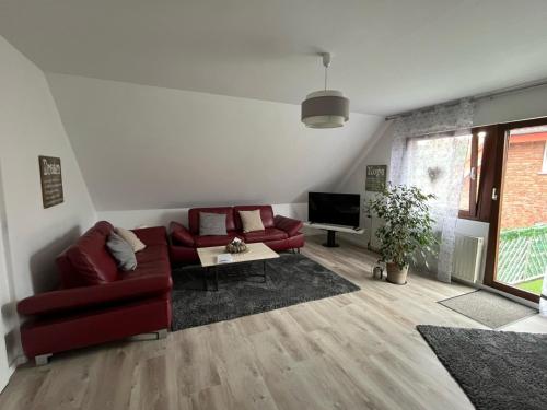 a living room with a red couch and a tv at Ferienwohnung Kleine Auszeit in Ascheberg