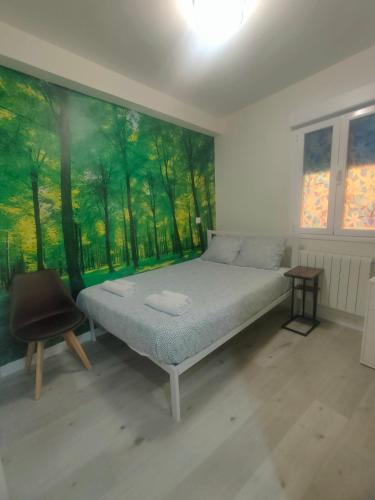a bedroom with a bed and a painting on the wall at Apartamentos Megaleon in Segovia