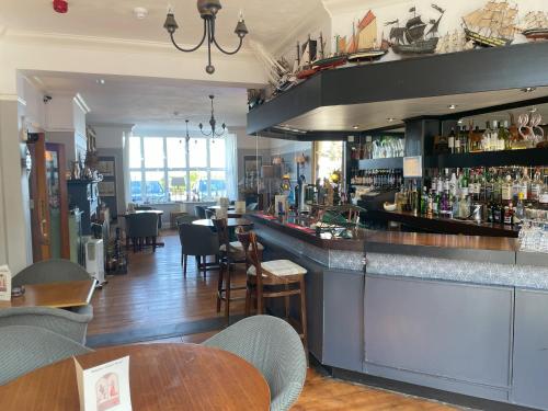 a bar in a restaurant with tables and chairs at Knights Court in Great Yarmouth