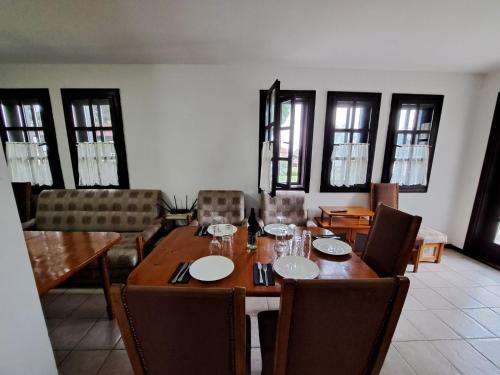 a dining room with a wooden table and chairs at Кедър 5 in Dolna Banya
