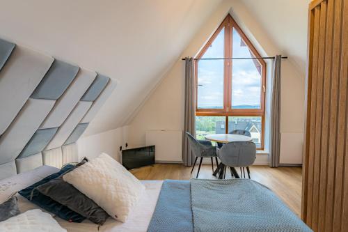 a bedroom with a bed and a large window at Mountain Palace Tatra Resort & SPA in Kościelisko