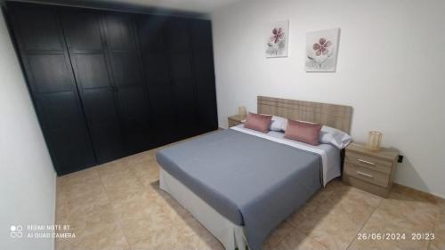a bedroom with a bed and a black cabinet at Garza Attic House in Ojos de Garza