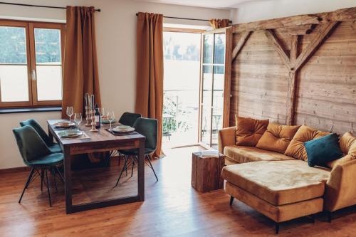 a living room with a couch and a table at Chalet-Apartments Am Schmiedhof in Vogtareuth