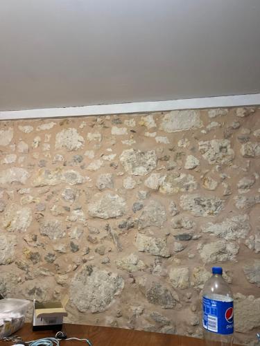 un mur de pierre avec une bouteille d'eau dessus dans l'établissement Loft en pierres apparentes, à Coursan