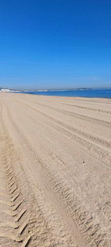 an empty beach with tire tracks in the sand at Appartement Marina Beach, Mdiq in M'diq