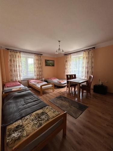 a room with a bed and a table and chairs at Leśniewscy - Pokoje Gościnne in Ojców