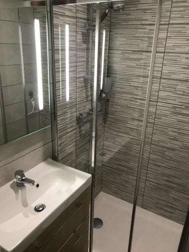 une salle de bain avec un lavabo blanc et une douche dans l'établissement El Capullo - Appartement en Rdc avec cour en centre ville, à Châteauroux