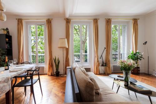un salon avec un canapé et une table dans l'établissement Charming French Style Apartment with Eiffel Tower View Prime Location Near Top Attractions, à Paris