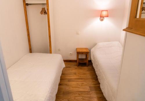 - 2 lits dans une petite chambre avec une table dans l'établissement Résidence Les Hauts De Preclaux - Studio avec vue splendide sur le front de neige MAE-3691, aux Orres