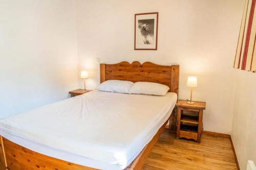 une chambre avec un grand lit blanc avec deux lampes dans l'établissement Résidence Les Hauts De Preclaux - Appartement ensoleillé au coeur des Orres 1800 MAE-3671, aux Orres