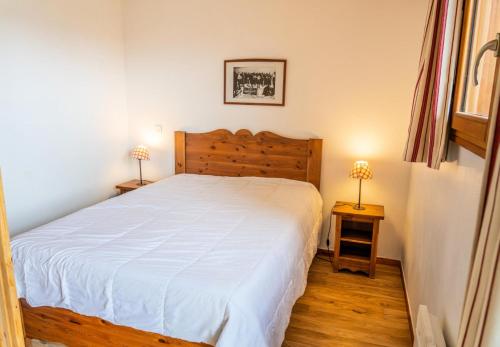 une chambre avec un grand lit blanc et deux lampes dans l'établissement Résidence Les Hauts De Preclaux - Appartement 2 pièces au coeur des Orres 1800 MAE-3681, aux Orres