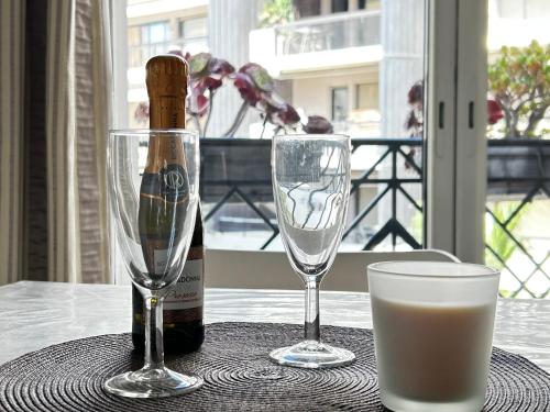 une bouteille de vin et deux verres sur une table dans l'établissement Elegant studio a 50m de la Croisette et ses plages - Ada Serenity Beach, à Cannes