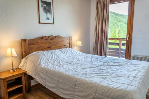 une chambre avec un lit et une grande fenêtre dans l'établissement Résidence Les Hauts De Preclaux - Appartement spacieux et chaleureux au Orres 1800 MAE-3411, aux Orres