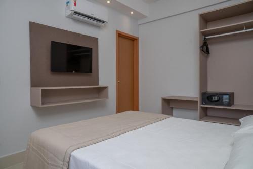une chambre avec un lit et une télévision à écran plat dans l'établissement Lagoa Eco Towers - Apartamento para ate 7 pessoas com acesso a piscinas, quiosques, restaurante e muito mais, à Caldas Novas