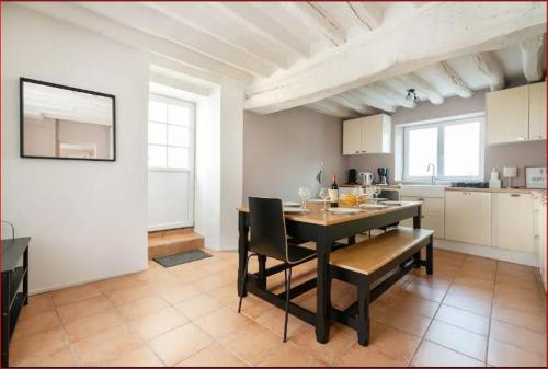 une cuisine et une salle à manger avec une table et des chaises dans l'établissement Prolongez la magie aprés DisneyLand Paris, à Saint-Germain-sur-Morin