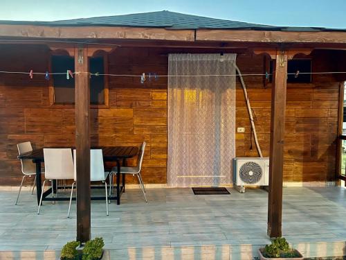 a screened in porch with a table and a fan at Guest House DEA in Vlorë