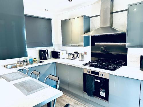 a kitchen with blue cabinets and a stove top oven at Grace Court in Aberdeen