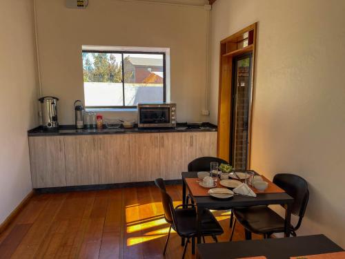 a dining room with a table and chairs and a microwave at Hostal El Valle in Illapel