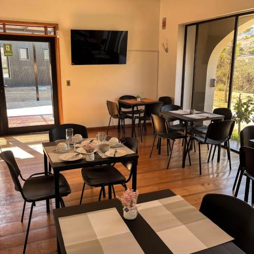 a dining room with tables and chairs and a television at Hostal El Valle in Illapel
