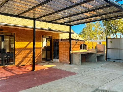 an outdoor patio with awning and a grill at Hostal El Valle in Illapel