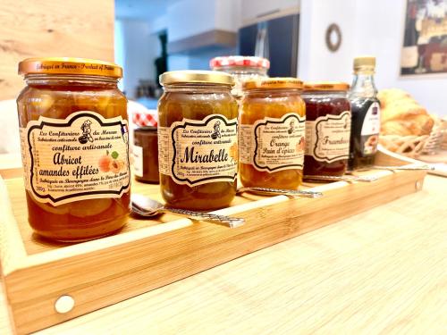a group of jars of honey on a wooden shelf at Hotel Particulier Les Rêveries du CLOS derrière St Jean Vignes &Spa Adult Only in Pommard
