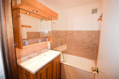 une salle de bain avec un lavabo, un miroir et une baignoire dans l'établissement Résidence L'everest - 2 Pièces 5 pers - L'EVEREST - PLAGNE CENTRE MAE-5814, à Aime La Plagne