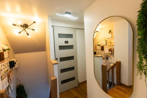 un couloir avec un miroir et un ventilateur de plafond dans l'établissement Gîte Saint Amour, au Pin