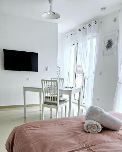 une chambre avec un lit, une table et une télévision dans l'établissement Charmant studio 
