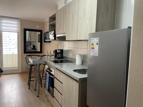 a kitchen with a refrigerator and a counter top at Departamento Nuevo Centro Osorno in Osorno