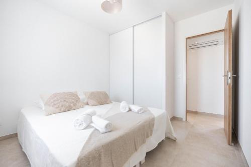 a white bedroom with a bed with towels on it at Villa Thym in Marignane
