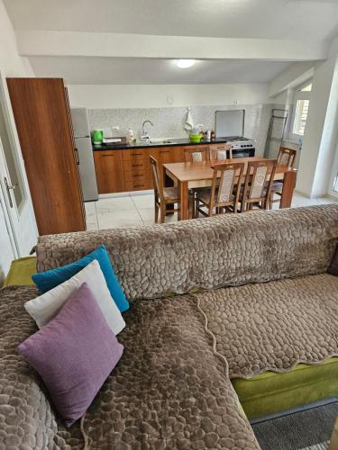 a couch sitting in a living room with a kitchen at XXL APARTMENTS CiTY CENTAR in Bitola