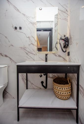 a bathroom with a sink and a mirror at LA PLAZA luxury suites NEA VRASNA in Nea Vrasna