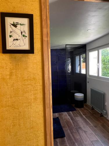 a bathroom with a shower and a picture on the wall at Wanatan Chambre Deluxe in Penmarcʼh
