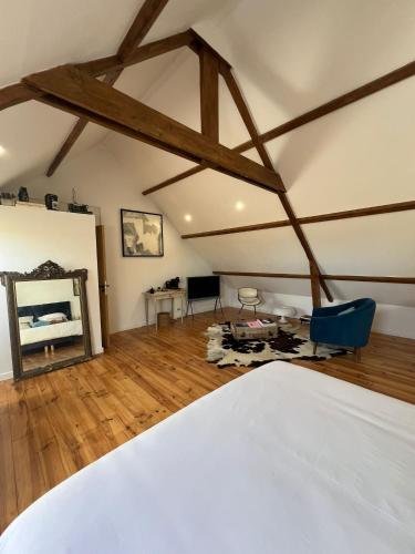 a bedroom with a white bed and a mirror at Wanatan Chambre Deluxe in Penmarcʼh
