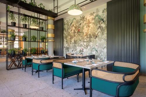 a dining room with tables and chairs and a mural at Ocean's Creek Beach Hotel in Balaclava
