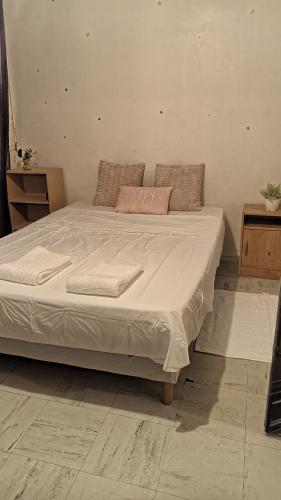 une chambre avec un lit avec un couvre-lit blanc dans l'établissement Apartamento de ferias, à Bezons